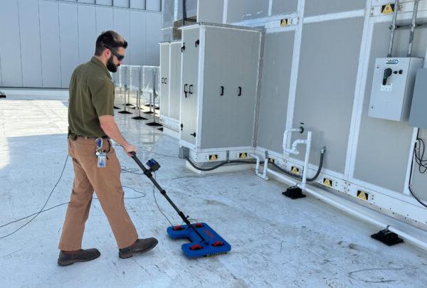 质量 Coordinator Grant Foreman operates the IntegriScan Electronic Leak Detection system on the roof of Miller Electric Center, the Jacksonville Jaguars practice facility and sports performance center.